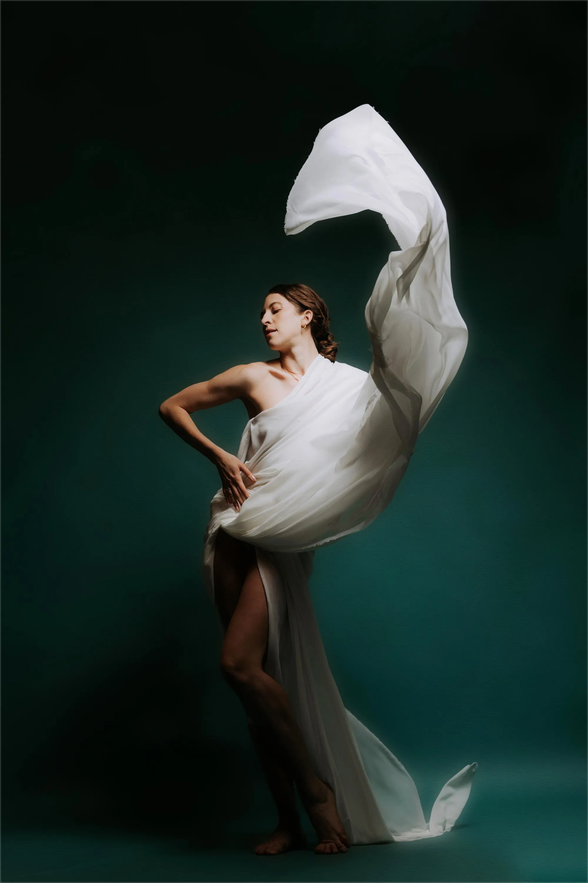 Alex Schooling turning inside a sweep of white silk against teal