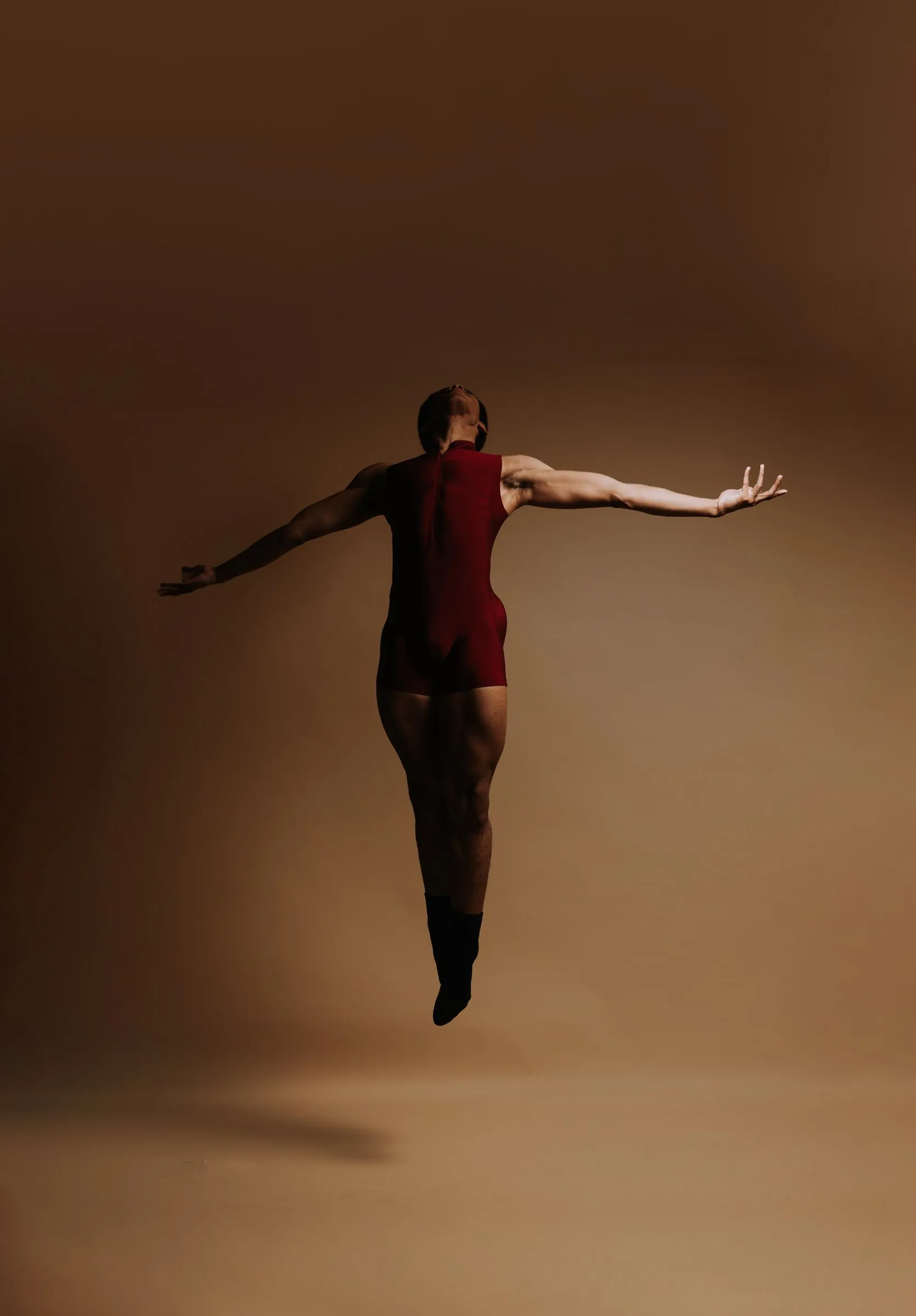 A dancer suspended mid-jump with arms extended