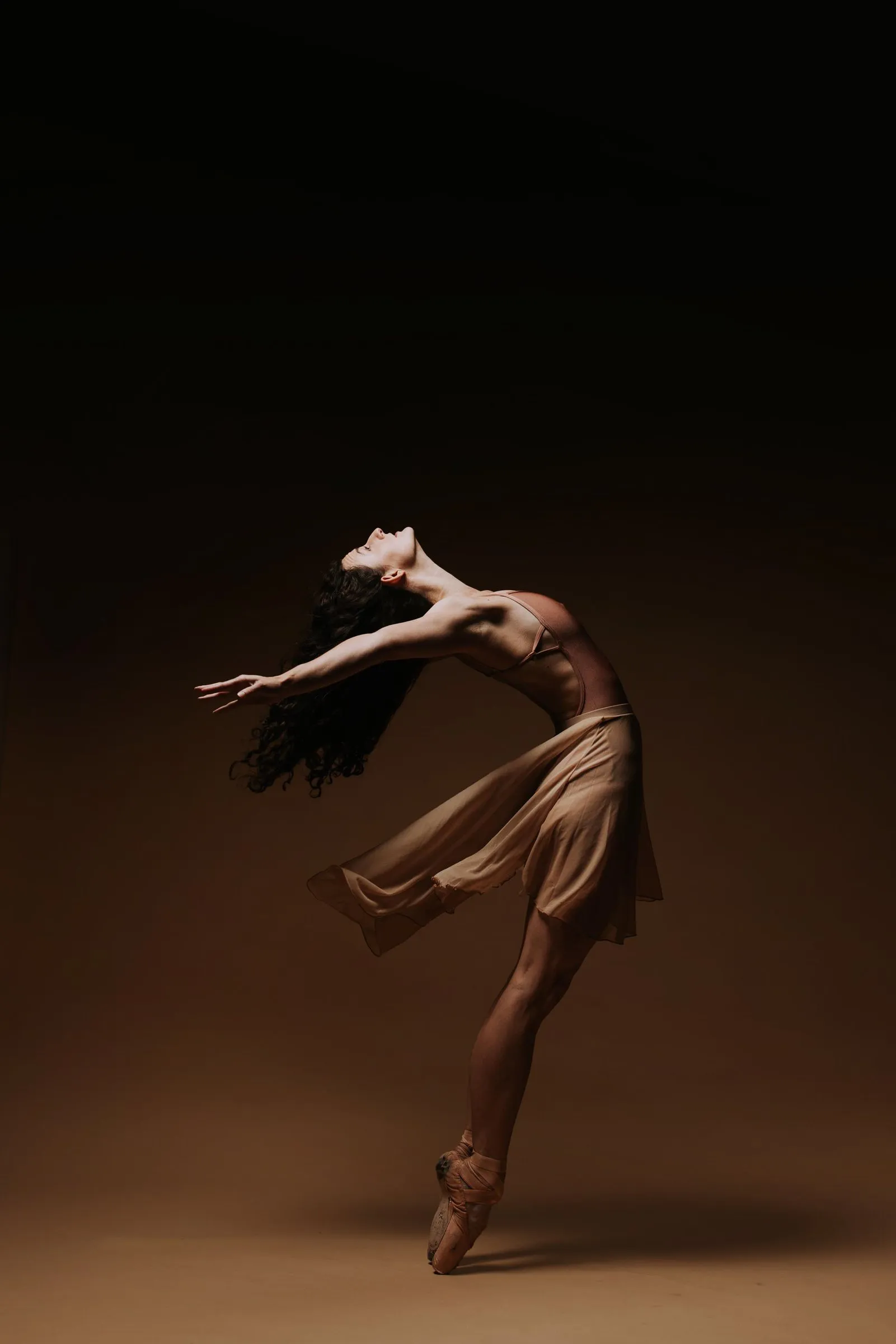 Grace Manuel in a deep backbend, hair in motion